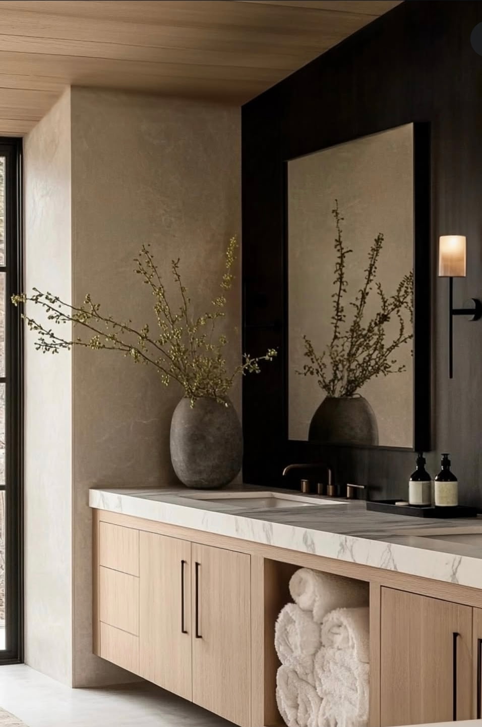 Moody designer bathroom vignette with stone vessel and oak vanity